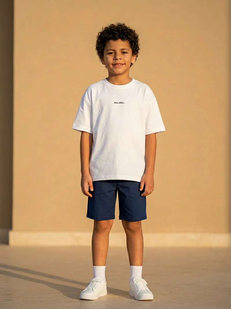 Boy wearing BALABEL Cosmic white tee and navy shorts